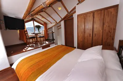 a bedroom with a bed with a television and a table at Casa San Blas Cusco Boutique Hotel in Cusco