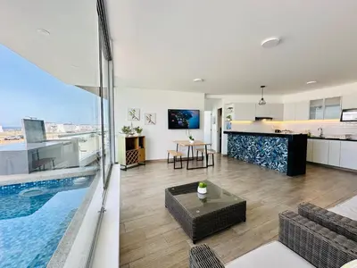 a living room and kitchen with a swimming pool at Moderno Departamento con Piscina y Parrilla, 3 min de la playa, Asia in Asia