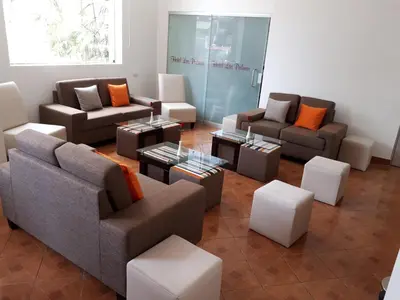 a living room with couches and chairs and tables at Hotel Las Palmas in Lima