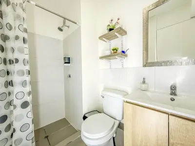a white bathroom with a toilet and a sink at Departamento exclusivo con vista al mar in Lima