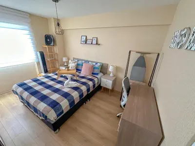 a bedroom with a bed and a desk with a mirror at Departamento exclusivo con vista al mar in Lima