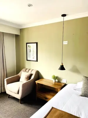 a bedroom with a bed and a chair and a table at CASA MONTES PARDO in Cusco