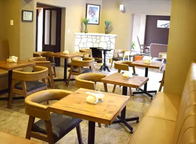 a restaurant with tables and chairs and a fireplace at CASA MONTES PARDO in Cusco