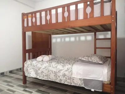 a wooden bunk bed with two pillows on it at Mi Chanchamayo, family. in La Merced