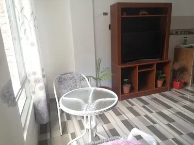 a living room with a table and a television at Mi Chanchamayo, family. in La Merced
