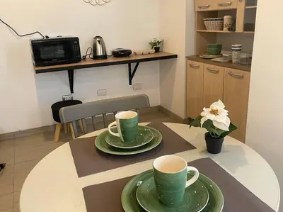 a table with two green cups and plates on it at Huancayo Suite 3, cómodo MiniDpto cama matrimonial in Huancayo