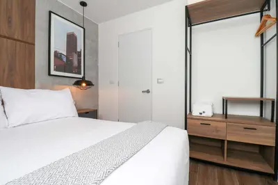 a bedroom with a white bed and a dresser at Actual by Wynwood House in Lima