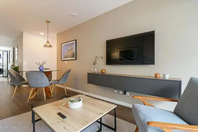 a living room with a couch and a tv on a wall at Actual by Wynwood House in Lima