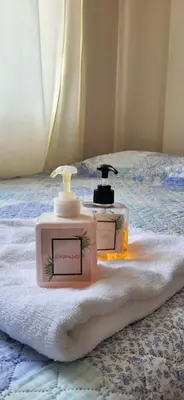 two bottles of soap sitting on a bed at L & P Apart Punta Hermosa in Punta Hermosa