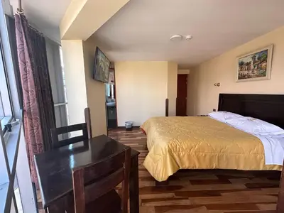 a bedroom with a bed and a dresser in it at Hotel Inka Palace Huayna Ccapac Cusco in Cusco