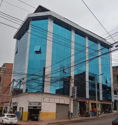 a blue glass building on a city street at Hotel Inka Palace Huayna Ccapac Cusco in Cusco