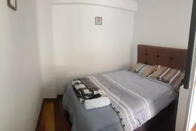 a bedroom with a bed with a brown headboard at Cusco Central Aparment in Cusco