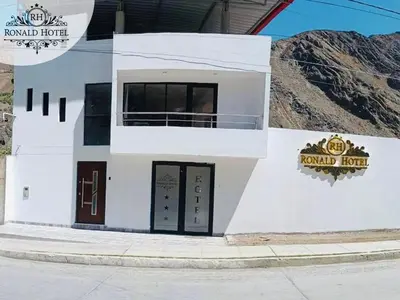 a white building with a sign that reads round hotel at RONALD HOTEL in Churín