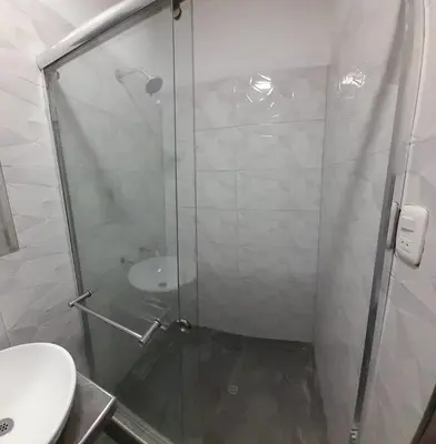 a bathroom with a glass shower and a toilet at RONALD HOTEL in Churín