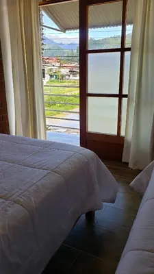 a bedroom with a bed and a large window at Las Yungas Hospedaje in Oxapampa