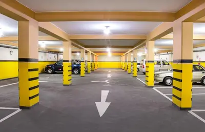 a parking garage with yellow columns and cars in it at Hotel Savilayo in Ica