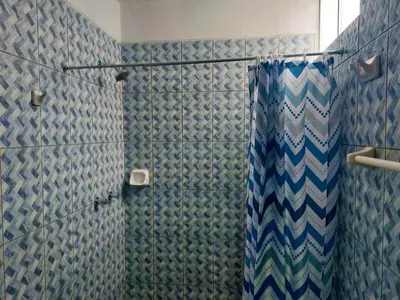 a bathroom with a shower with blue and white tiles at Kasanty House in Paracas