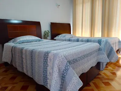 two beds sitting next to each other in a bedroom at Kasanty House in Paracas