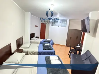 a room with two beds and a tv in it at Hotel Turikys Churin in Churín