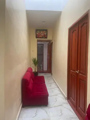 a living room with a red couch and a plant at Mundo Viajero Saphy in Cusco