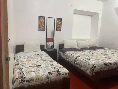 a bedroom with two beds and a mirror and a window at Mundo Viajero Saphy in Cusco