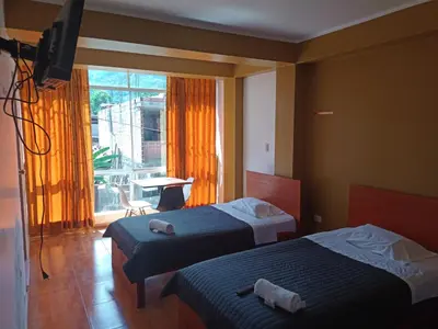 a hotel room with two beds and a television at GOLDEN DOOR in La Merced