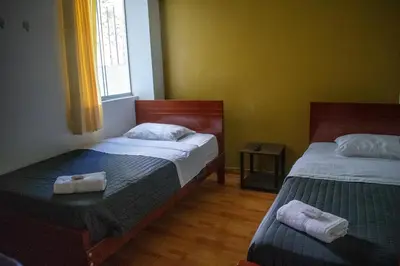 a bedroom with two beds and a window at GOLDEN DOOR in La Merced