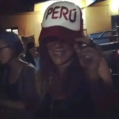 a woman wearing a cap with the word peru on it at flying monkey hostel in Nazca