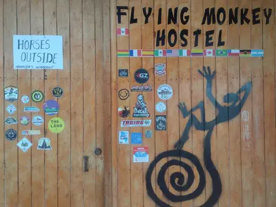 a wall with a bunch of stickers on it at flying monkey hostel in Nazca