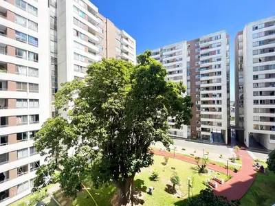 a tree in a park in front of tall buildings at Lindo Apartamento en Condominio Privado in Lima