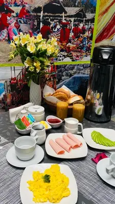 a table with plates of food and flowers on it at Hotel Valle Andino in Cusco