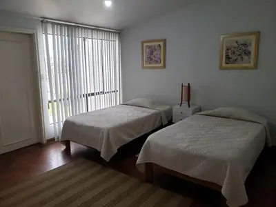 two beds sitting in a room with a window at Amplio y Acogedor Departamento en San Miguel, Lima in Lima