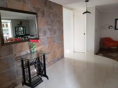 a room with a vase of flowers on a table at Amplio y Acogedor Departamento en San Miguel, Lima in Lima
