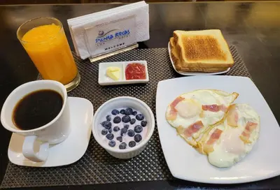 a table with a plate of breakfast food and a cup of coffee at Hotel Punta Rocas - Huacho in Huacho