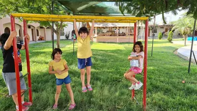 a group of children playing on a swing at Hospedaje El Cascabel in Sunampe