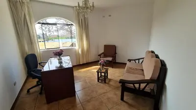 a living room with a table and chairs and a window at Hospedaje El Cascabel in Sunampe