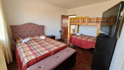 a hotel room with a bed and a bunk bed at Hospedaje El Cascabel in Sunampe