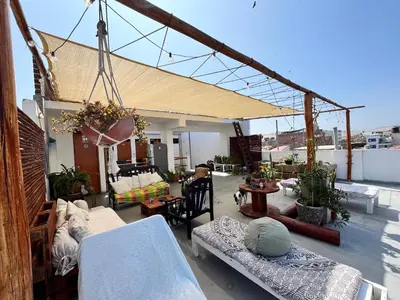 a living room with couches and chairs on a roof at Bravo Hostels: Surf House in Punta Hermosa