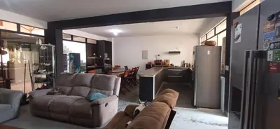 a living room with a couch and a kitchen at Bravo Hostels: Surf House in Punta Hermosa