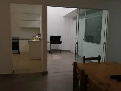 a room with a table and a kitchen with a mirror at J&B Aparment 1 Punta Hermosa in Punta Hermosa