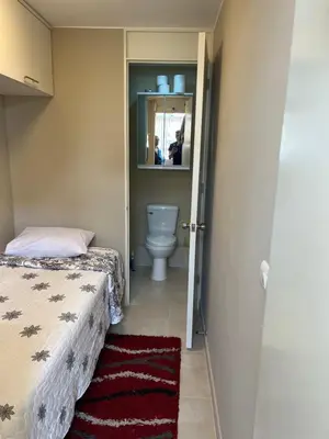 a bathroom with a bed and a toilet and a mirror at Moderno Apartamento en Condominio Alto Venezuela in Lima