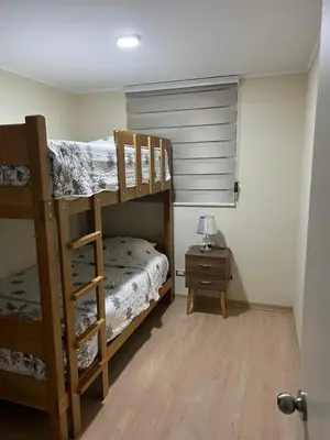 a bedroom with two bunk beds and a night stand at Moderno Apartamento en Condominio Alto Venezuela in Lima