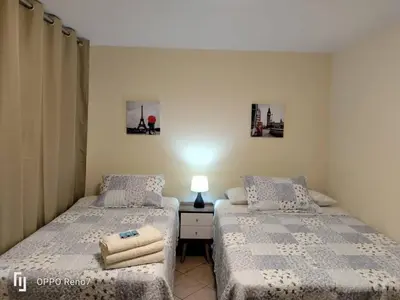 a bedroom with two beds and a table with a lamp at Casa Bonita in Lima
