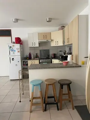 a kitchen with a counter and two stools at Watermanhouse, Punta Hermosa in Lima