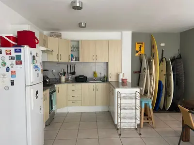 a kitchen with wooden cabinets and a white refrigerator at Watermanhouse, Punta Hermosa in Lima