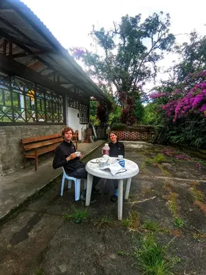 two women sitting at a table in a garden at la casa de mamá in Huayopata