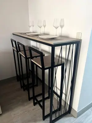 a black table with two chairs and wine glasses at Moderno mini departamento de estreno in Lima
