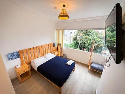 a bedroom with a blue bed and a window at Casaroma Hostels in Lima