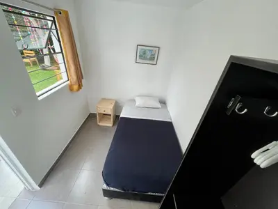 a small bedroom with a bed in the corner at Casaroma Hostels in Lima