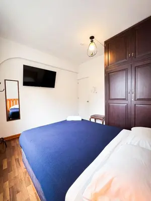 a bedroom with a large bed with a blue blanket at Casaroma Hostels in Lima